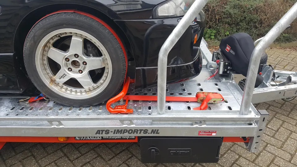 Wiel en oranje spanband op trailer