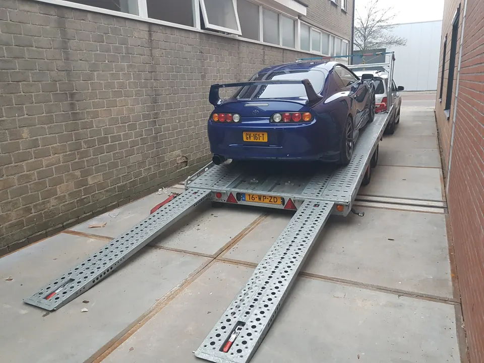Blauwe Toyota Supra A80, achteraanzicht op oprijplaten