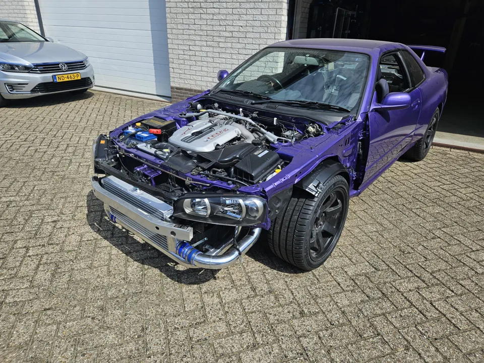 Paarse aangepaste coupé met zichtbare motorruimte buiten